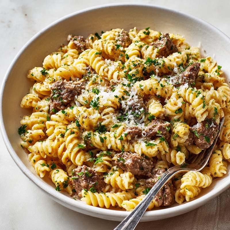 serving bowl of creamy garlic butter beef pasta with parsley