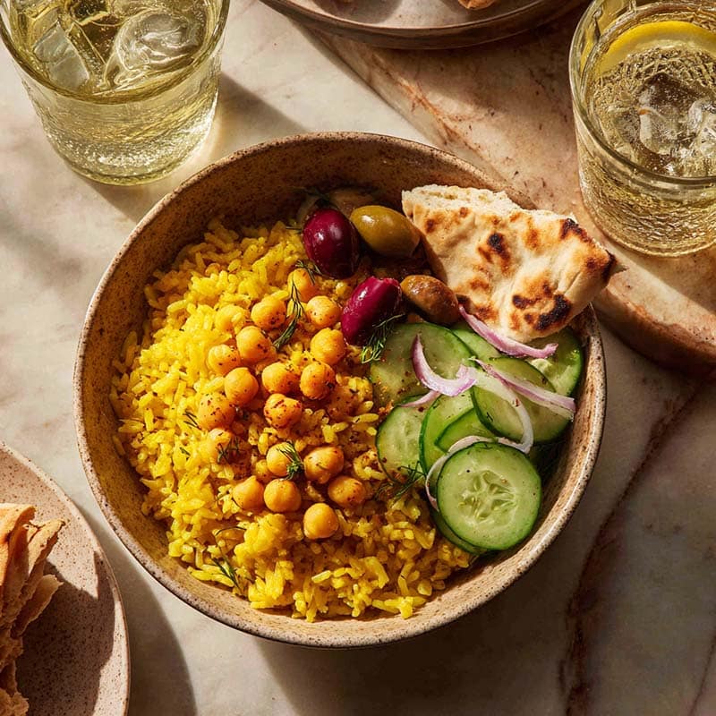 Served turmeric chickpea rice bowl with sides and drink