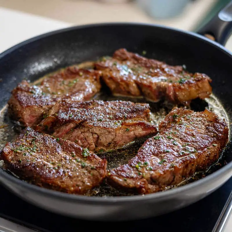 steak searing in skillet for queso rice