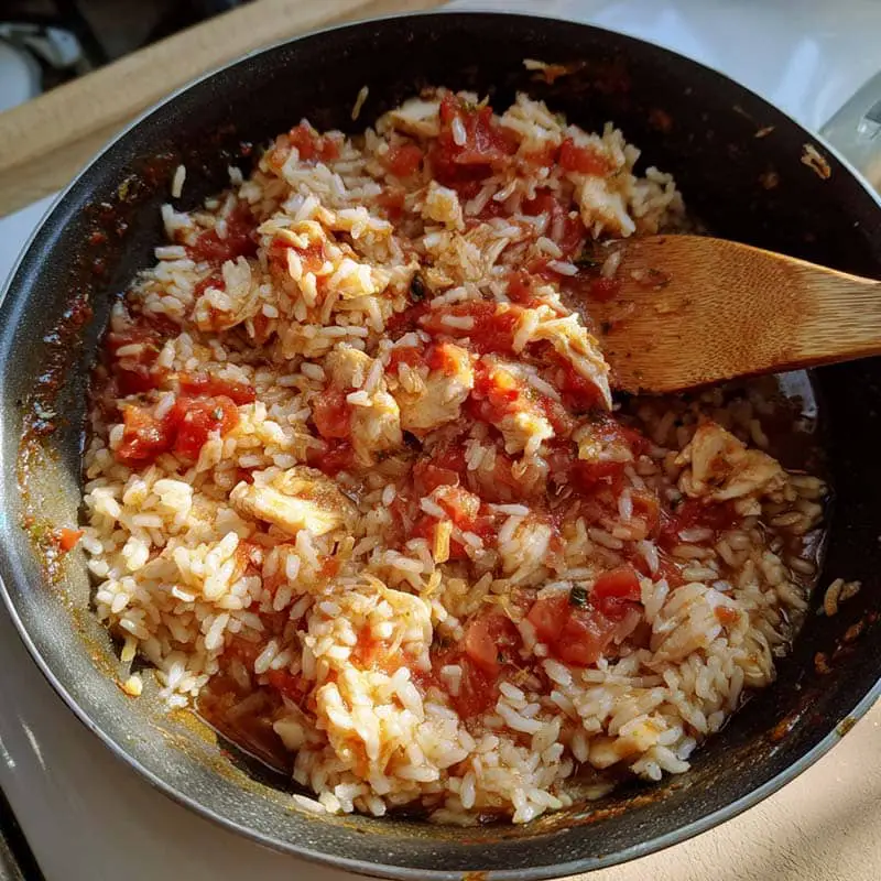 cooking tomato rice for queso steak bowl
