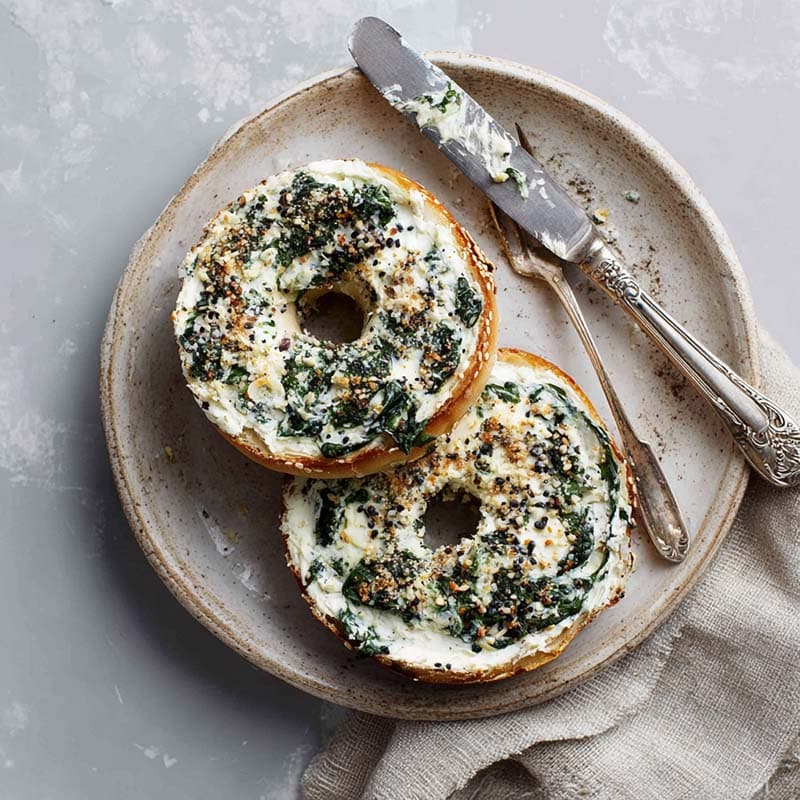 spinach-bagel-served.jpg sliced spinach cottage cheese bagel with cream cheese